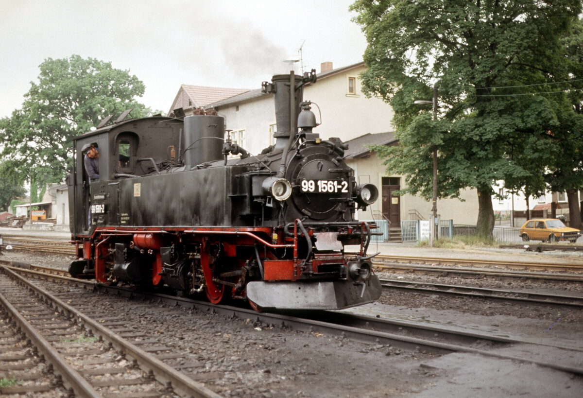 Die DR 99 1561 - 1909 von Hartmann Chemnitz an die Sächsischen Staatseisenbahnen mit der Fahrzeugnummer 151 geliefert - nähert sich am 29.07.1991 dem Bf. Radeburg. Bis 1970 trug die Lok bei der DR die Nummer 99 561.