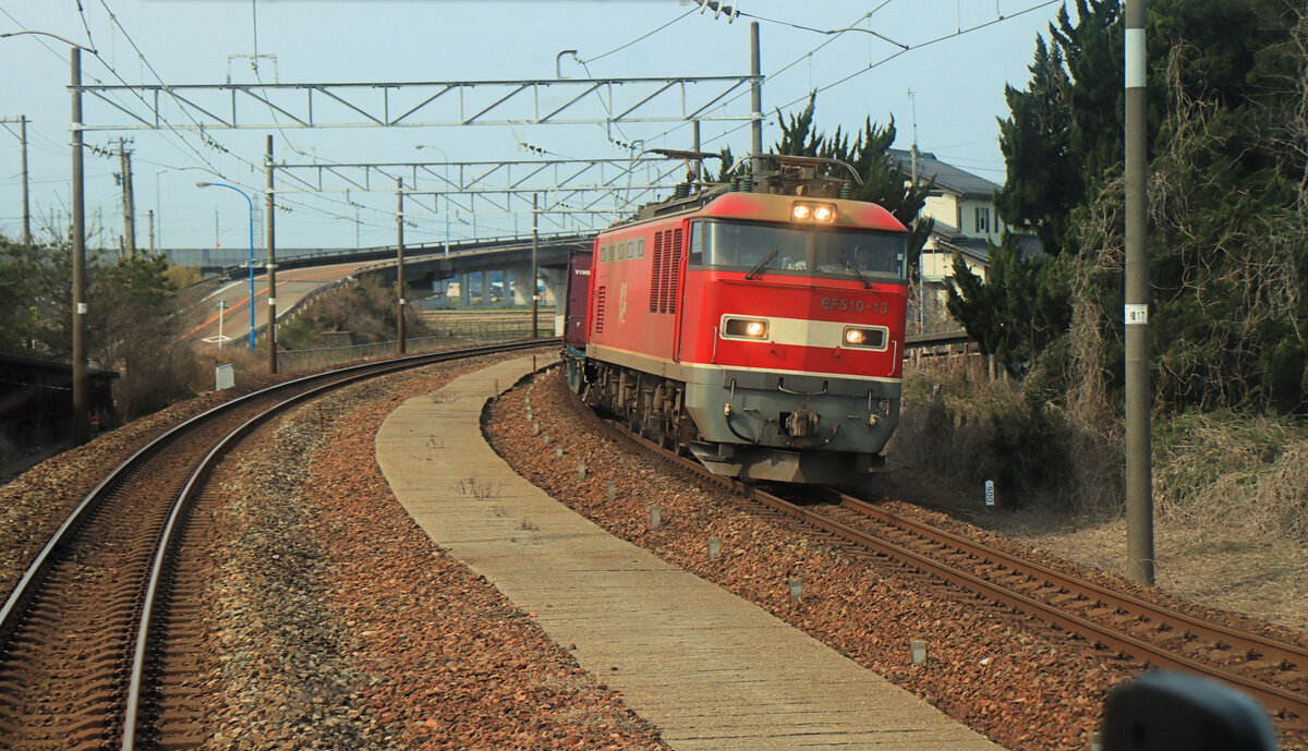 Die IR Ishikawa Privatbahn: Die alte Hauptstrecke dem Japanischen Meer entlang gehört seit dem 16.März 2024 zwar der IR Ishikawa Bahn, dient aber weiterhin den Güterzügen von JR Freight (JRF) auf ihrer Fahrt aus dem zentraljapanischen Gebiet um Osaka und Kyoto hinauf in den Norden, teils bis auf die Nordinsel Hokkaidô. Hier kommt gerade JRF Lokomotive EF510-13 bei Iburibashi entgegen, 19.März 2024 