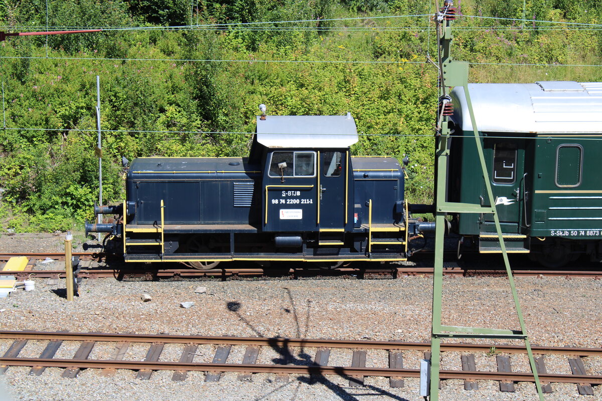 Die Kleindiesellok der Skandinaviska Jernbanor mit der Bezeichnung S-BTJB 98 74 2200 211-1 steht im Bahnhof Uddevalla C vor einigen Reisezugwagen der Bahngesellschaft.

Uddevalla C, 20.07.2023