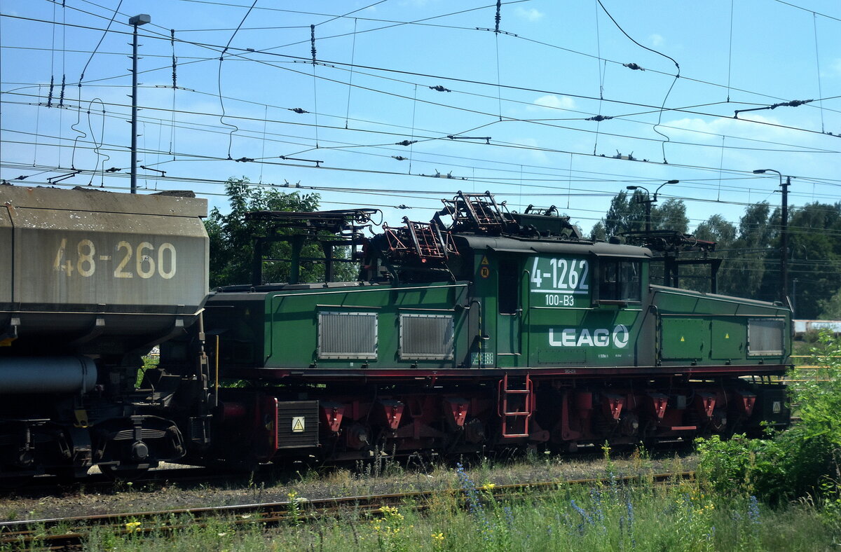 Die LEAG EL 2 Lok  4-1262/100-B3  am 26.06.24 am Kraftwerk Jänschwalde abgestellt mit den Schüttgutwagen für die Braunkohle (Bild aus dem Bahnfenster RB 43 nach Falkenberg). 