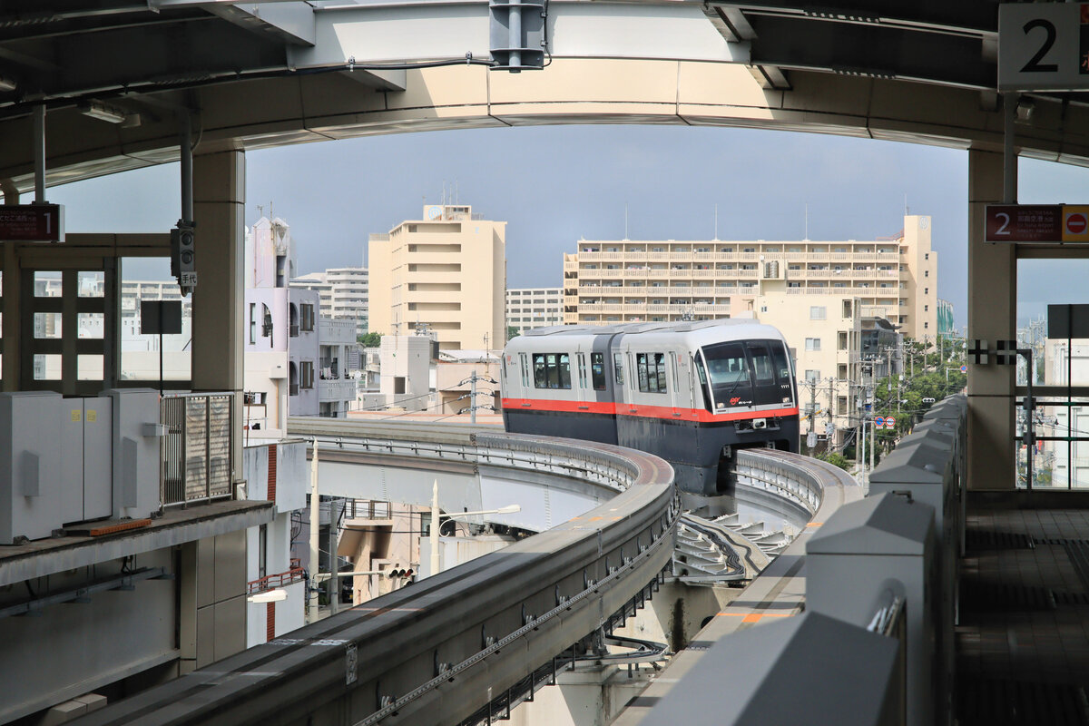 Die Monorail von Naha, Hauptstadt von Okinawa: Zug 1111 bei der Einfahrt in Shuri. 22.April 2023.  Der Wagenpark umfasst 19 zweiteilige Triebzüge (1101+1201 ff), 1101 bis 1112 aus dem Eröffnungsjahr 2003, 1109 von 2009, die weiteren von 2016/17.  Jetzt werden längere, dreiteilige Züge beschafft, ein Prototyp ist bereits abgeliefert. 