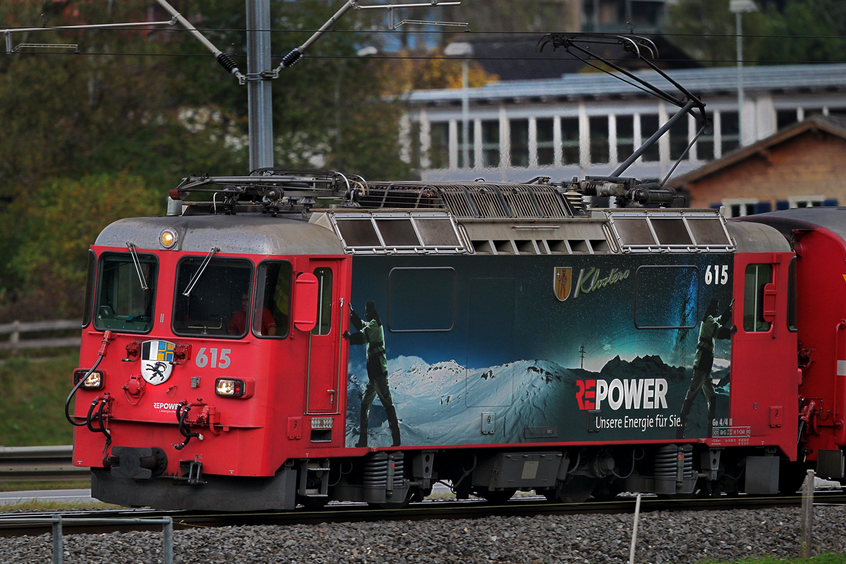 Die SLM Lok Ge 4/4 II 617  Klosters  der Rhb mit der Werbung für Re Power mit einem RE nach Landquart bei der Durchfahrt in Schiers.Bild vom 20.10.2014