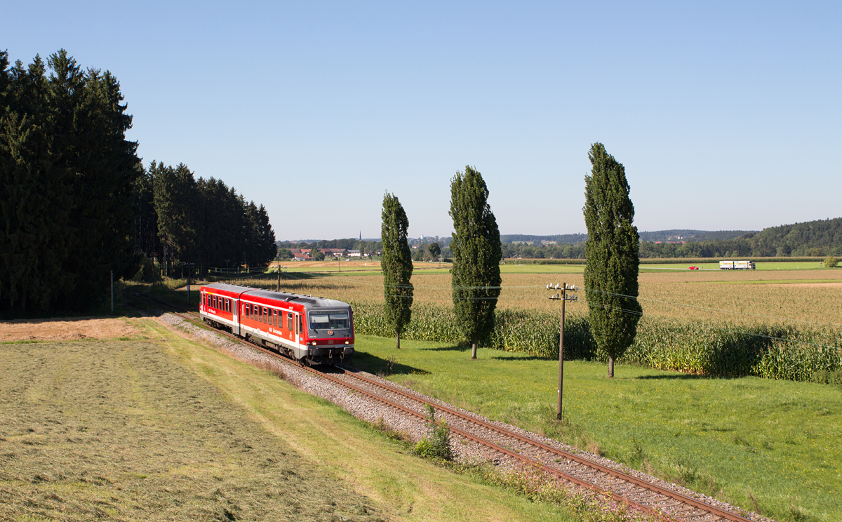 Drei markant-schöne Bäume bildeten bei Nunhausen ein Motiv, in dem 628 560-5 von Traunreut nach Traunstein am Nachmittag des 25.08.16 zu sehen ist.