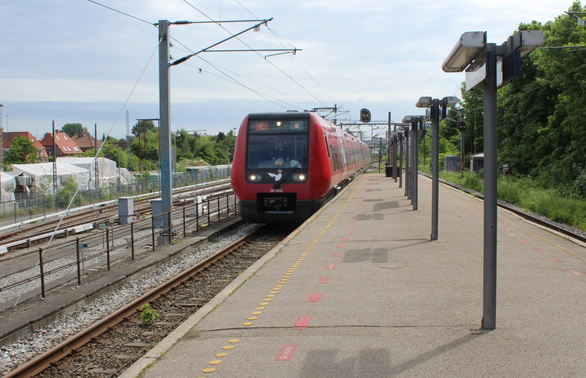 DSB S-Bahn Kopenhagen: Eine S-Bahngarnitur (LHB/Siemens-SA 9152) erreicht am 24. Mai 2014 den S-Bf Vanløse. Der Zug fährt in Richtung Frederikssund. - Links unten konnte man früher in die S-Bahnlinie F umsteigen, als sie noch von und nach Frederiksberg fuhr - jetzt enden hier die Züge der Kopenhagener Minimetro, die zwischen Vanløse und Flughafen Kopenhagen / Vestamager fahren. Wünscht man, die S-Bahnlinie F (Ny Ellebjerg - Nørrebro - Hellerup) zu benutzen, muss man am S-Bf Flintholm umsteigen.