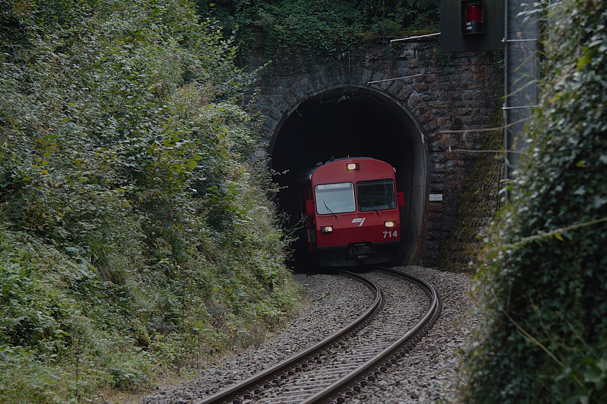 Ein Zug der Chemins de fer du Jura fährt am 21.09.2024 bei Bollement mit dem führenden ABt 714 aus einem Tunnel.