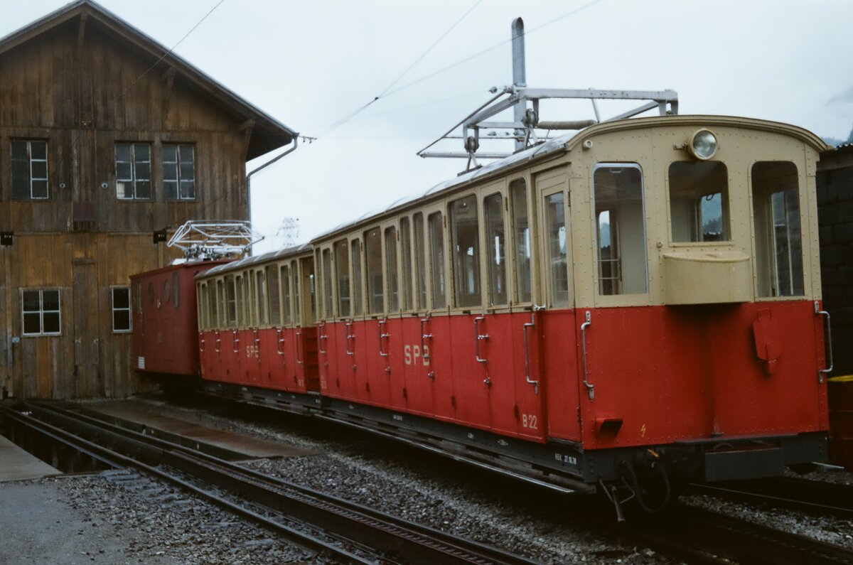 Ein Zug der Schweizer Schynige Platte Bahn vor dem Wagenschuppen in Wilderswil mit einer Ellok der Baureihe He 2/2 (1983)