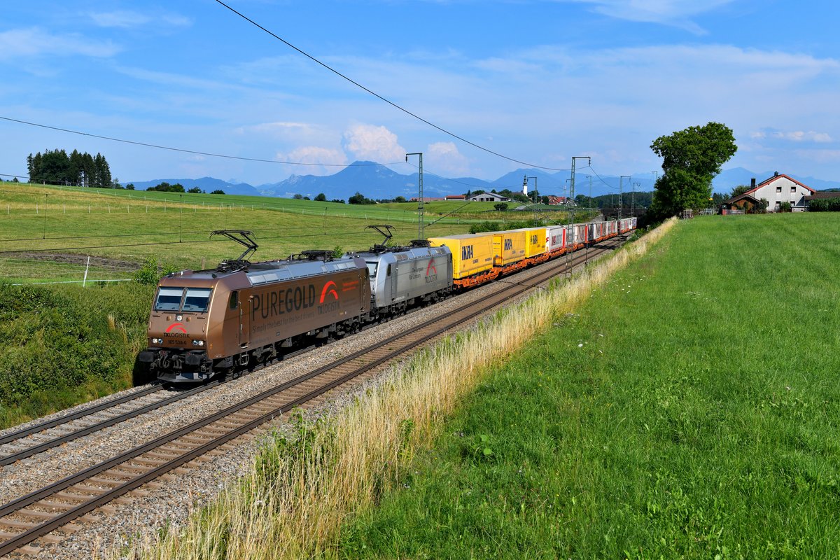 Eine nette Überraschung gab es noch am Nachmittag des 20. Juli 2019 für die eigentlich für die umgeleiteten Züge von der Passauerbahn an der Strecke stehenden Fotografen. Der DGS 41872 von Triest nach Bettembourg war an diesem Tag mit den 185 538 und 539 von TXL bespannt. Bei Hörafing im Berchtesgardener Land gelang die Aufnahme der goldenen Werbelok, die den besten Lokführern das hochwertigste Arbeitsmaterial in Aussicht stellt, sollten sie sich für den werbenden Arbeitgeber entscheiden. Auch erfreulich war die Auslastung des aufgrund seiner Ladung auch als  Mars  bekannten Zuges. Die gefürchteten Lücken in der Beladung waren an diesem Tag nicht gegeben. Im Hintergrund erkennt man die Salzburger Hausberge.  