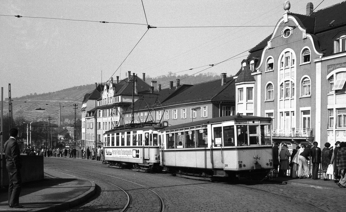 END Straßenbahn Esslingen-Nellingen-Denkendorf__Die erste Strecke der meterspurigen Überlandstraßenbahn, von Esslingen hinauf auf die Filderhöhe nach Nellingen und Denkendorf, wurde 1926 eröffnet. 1929 folgte die Strecke von Nellingen über Scharnhausen nach Neuhausen. Am 28. Februar 1978 wurde die Straßenbahn eingestellt und durch Busse ersetzt. Im Bild fährt Tw 10 [ME 1942] mit Bw 28 [ME 1927] von der Pliensaubrücke hinunter zur Endschleife auf dem Esslinger Bahnhofsplatz. Die wartenden Menschen erwarten den Fasnachtsumzug.__20-03-1976 