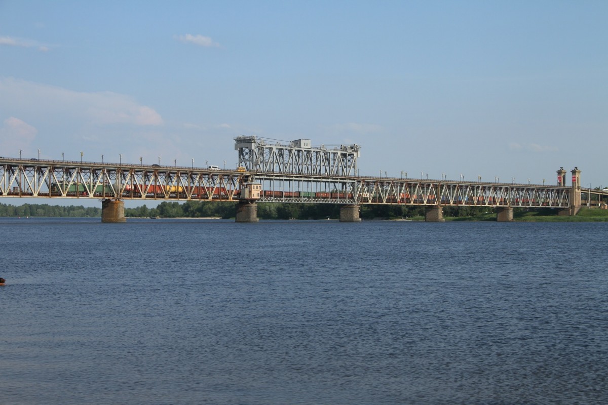 Fleißig schleppen die WL 80 Lokomotiven die scheinbar unendlich lange Reihe von Wagons hinter sich her. Hier zu sehen ist die Brücke von Krementschuk welche im oberen teil auch von Autos Bussen und LKW´s genutzt wird. Die Brücke wird zur Zeit von Soldaten bewacht, da schon viele Schienen im ganzen Land von Terroristen gesprengt wurden. Viele Brücken über den Dnjepr gibt es nicht. Die nächste wäre erst wieder im Norden bei Tscherkassy, und im Süden bei Zaporoschje. Bild vom 10.06.2015