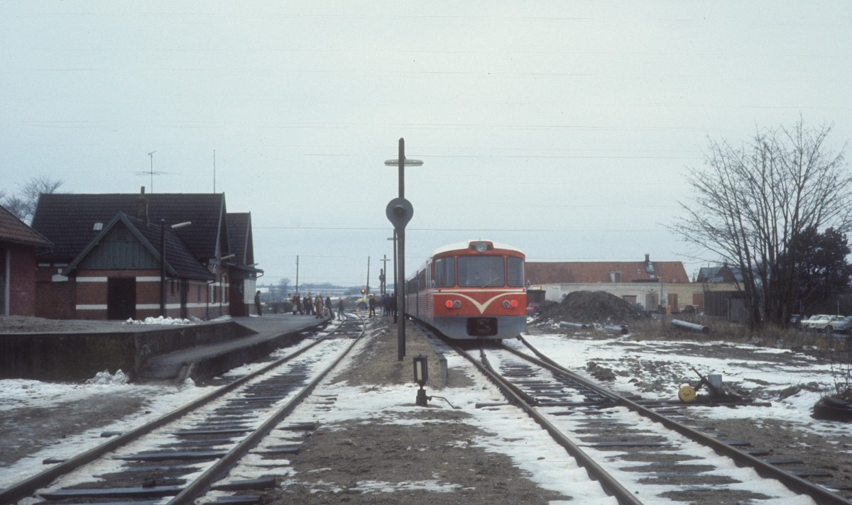 HFHJ (Hillerød-Frederiksværk-Hundested-Jernbane, auch Frederiksværkbanen  genannt): Bahnhof Ølsted am 23. Dezember 1976. - Ein Triebzug bestehend aus einem Triebwagen (Ym), einem Mittelwagen (Yp) und einem Steuerwagen (Ys) ist gerade angekommen. Der Zug fährt in Richtung Hundested.
