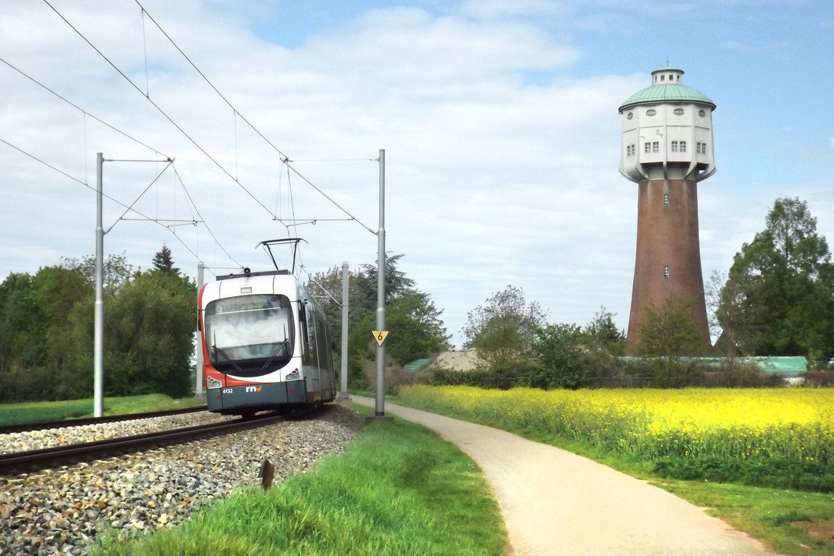 Hier sieht man die Varionbahn mit der Nummer 4132 der RNV, auch bekannt als Rhein Neckar Verkehr GmbH, kurz vor dem Betriebshof Edingen. Im Hintergrund zu sehen ist der Edinger Wasserturm.
