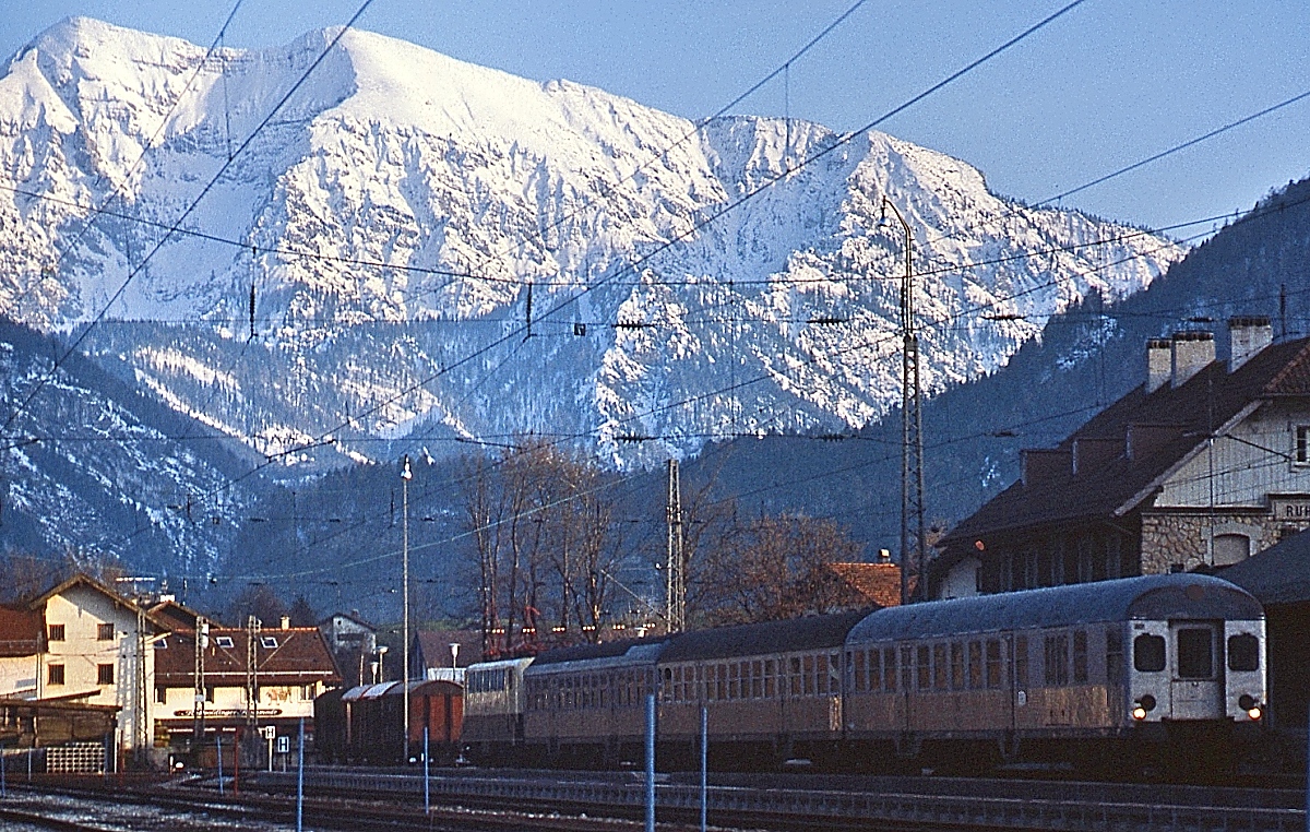 Im April 1982 steht eine unbekannte 141 im Bahnhof Rupolding am Ende eines Wendezuges nach Rupolding. Leider befanden sich die Loks immer in südlicher Richtung am Zug, so dass gescheite Aufnahmen mit der Alpenkulisse im Hintergrund so gut wie unmöglich waren. Immerhin war es so möglich, eine der sonst verschmähten  Hasenkästen  an der Zugspitze ins Bild zu setzen. Von den umfangreichen Bahnanlagen ist heute ledglich ein kümmerliches Gleis übriggeblieben.