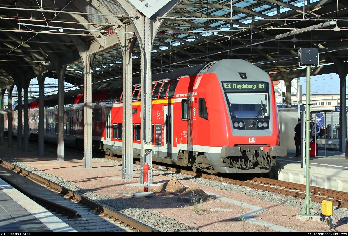 In der Bahnhofshalle von der Sonne angestrahlt wird DABpbzfa  Jenny Marx geb. von Westphalen  mit Zuglok 146 0?? der Elbe-Saale-Bahn (DB Regio Südost) als RE 16320 (RE30) nach Magdeburg Hbf, der in seinem Startbahnhof Halle(Saale)Hbf auf Gleis 10 E-G steht.
[27.12.2018 | 12:59 Uhr]