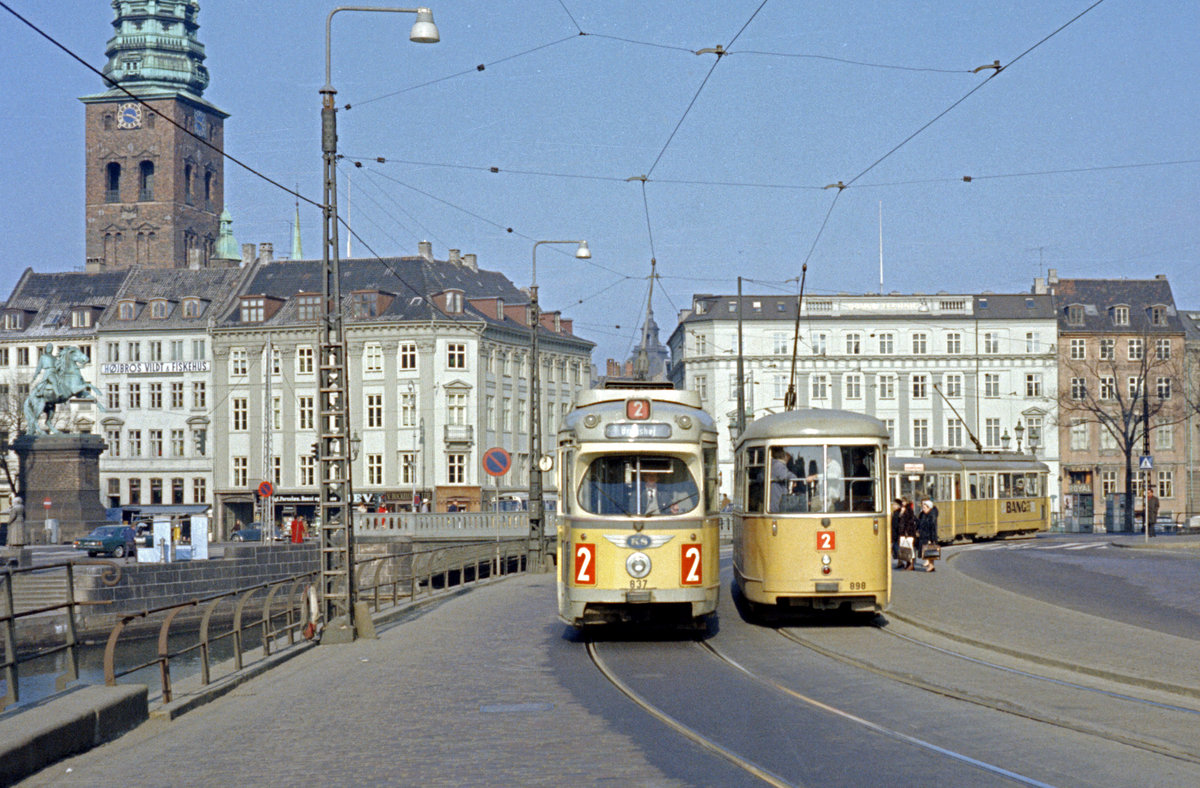 København / Kopenhagen Københavns Sporveje SL 2 (DÜWAG-GT6 837 / 898) København K, Stadtzentrum, Slotsholmen, Vindebrogade / Højbro am 5. April 1969. - Ganz links steht am Højbro Plads ein Ritterstandbild vom Bischof Absalon (um 1128 - 1201), der 1167 auf dem Slotsholmen (holm = Werder) eine Burg errichtete. Es gab schon vorher eine winzige Stadt und einen Hafen (altdänisch: 'hafn' = dänisch: 'havn') hier. - Dieser Hafen hieß beim dänischen Chronisten Saxo (etwa 1160 - (nach) 1208), der in lateinischer Sprache schrieb,  portus mercatorum  (altdänisch: Køpmannæhafn = Købmændenes havn = Hafen der Kaufleute). Aber nach dem Bau der Burg und nachdem Wohnungsgebäude an der Burg errichtet worden waren, entwickelte sich der 'Køpmannæhafn' zu einer eigentlichen Stadt. Und was ersichtlich ist: Der Name 'København' entwickelte sich aus dem altdänischen Namen. - Das Ritterstandbild vom Gründer der Stadt - so betrachtet man den Bischof Absalon - wurde vom dänischen Bildhauer Christan Gottlieb Vilhelm Bissen (1836 - 1913) gemacht und 1902 am Højbro Plads aufgestellt. - Scan eines Farbnegativs. Film: Kodak Kodacolor X.