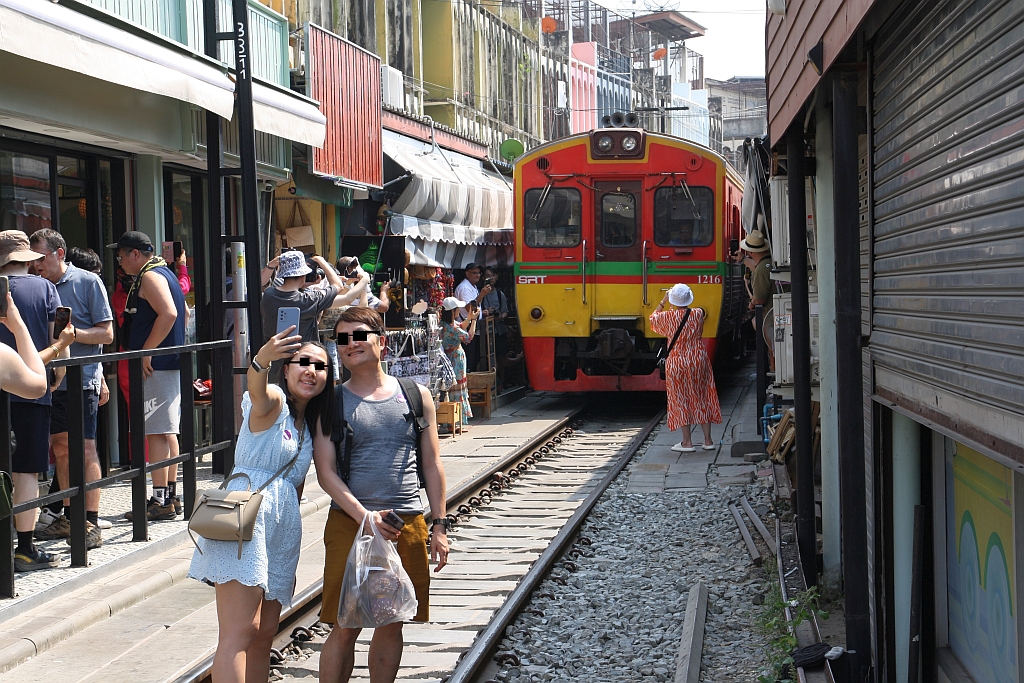 Kaum ist der NKF 1216 als letztes Fahrzeug des ORD 4385 (Ban Laem - Mae Klong) vorbei, stürmen auch schon die ersten Fotografen für Selfis auf die Gleise. - Markt bei der Mae Klong Station am 01.Mai 2024.