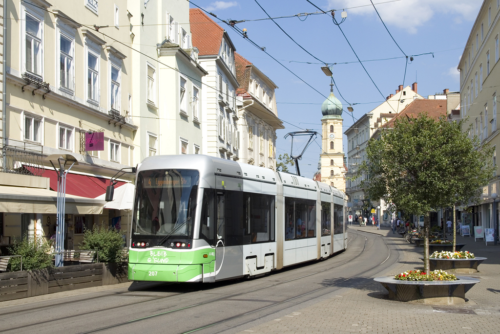 Manche Fotostandorte lassen sich auch in der dicht bebauten Grazer Innenstadt nur für einige wenige Wochen rund um die Sommersonnenwende und auch nur für ein nicht allzulanges Zeitfenster sonnig umsetzen, so auch dieses Motiv am Südtiroler Platz. Hier zeigt sich Variobahn 207 als Linie 4 in Richtung Eggenberger Straße am 7.7.2021.  