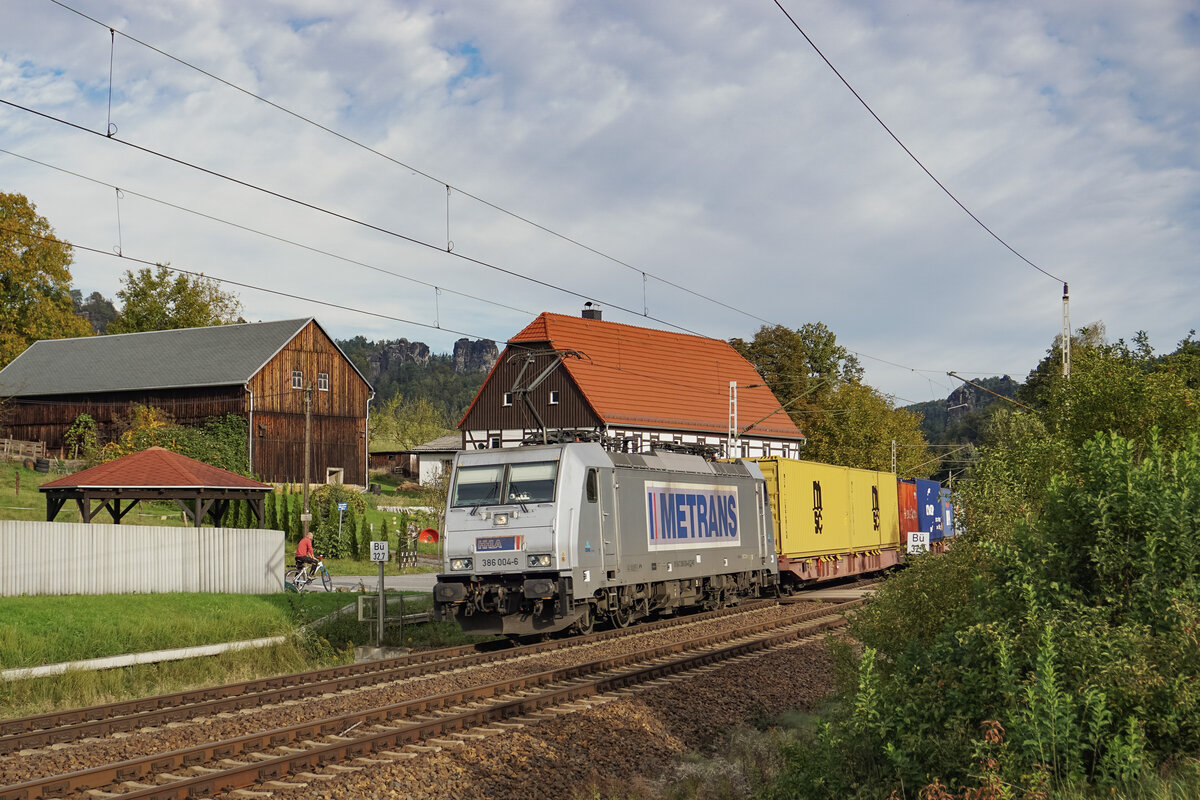 Metrans 386 004 überquerte am 10.10.2024 mit einem Containerzug den berühmten Bahnübergang mit dem Fachwerkhaus nahe Rathen, in Richtung Tschechien.