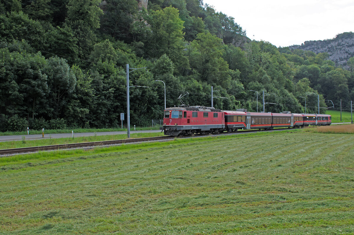 Mittwoch den 17.07.2024 um 09:21 Uhr in der  Aeussere Klus“ welche zur Gemeinde Oensingen (SO) gehört. Heute Mittwoch den 17. Juli 2024 feiert die OeBB (Oensingen – Balsthal Bahn) auf den Tag genau ihr 125-jähriges Bestehen. Hier kommt gerade der Regionalzug S22 26033 von Oensingen (ab 09:19 Uhr) nach Balsthal (an 09:27 Uhr) daher. Er besteht aus folgenden Fahrzeugen: Lokomotive Re 4/4 III 11350 (Re 430, 91 85 4430 350-9 CH-OeBBH), Zwischenwagen (Zweiteiler) B 50 85 2235 629-6 CH-OeBB, Steuerwagen ABDt 50 85 8035 197-3 CH-OeBB. Der Reguläre Personenverkehr wird an diesem Tag statt mit der SBB Komposition mit der OeBB eigenen Fahrzeug-Komposition geführt. Koordinaten GMS (Grad, Minuten, Sekunden): N 47° 17’ 48.3’’ O 7° 42’ 17.1’’