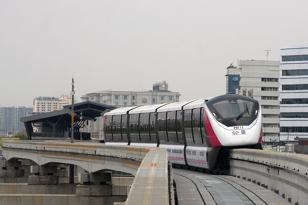 MRT PM13 (Hersteller: Bombardier Transportation + CRRC Nanjing Puzhen, Type Innovia Monorail 300) hat am 25.März 2024 die National Telecom Station (PK13, links im Hintergrund) in Richtung Lak Si Station (PK14) verlassen.