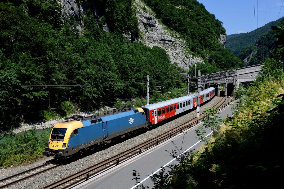 Nach Verlassen des 940 Meter langen Ofenauer Tunnels zwischen Golling-Abtenau und Sulzau hat der REX 1508 nach Wörgl, geführt von der ungarischen 470.002, gerade die Salzach überquert. Für diese Aufnahme war ein langwieriger Marsch durch das Unterholz erforderlich (22. Juni 2014).