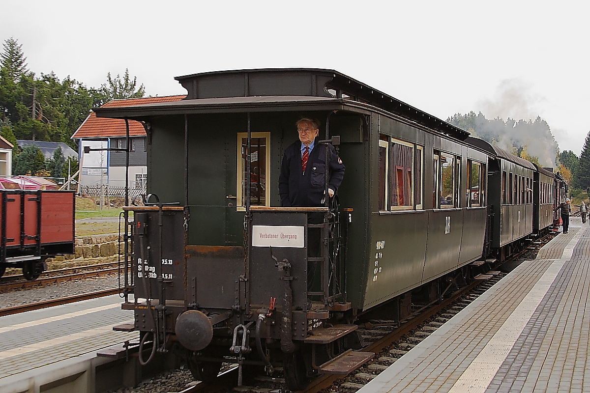 Nachdem am 20.10.2013 der links im Bild stehende Güterwagen im Bahnhof Benneckenstein abgestellt wurde, rangiert der Personenzug wieder an die restlichen Güterwagen heran, mit dener er heute als Sonder-PmG der IG HSB unterwegs war.
Der freundliche Herr auf der Plattform ist unser Reiseleiter Peter Schröder von der IG HSB, welcher uns Fahrgäste während aller Fahrten auf der dreitägigen Veranstaltung  Schmalspur-Romantik im Oktober  betreute und die Fahrten über Bordsprechanlage sehr sachkundig, umfassend und auch mit einer ordentlichen Prise Humor gewürzt, mit Informationen über alles Wissenswerte rechts und links der Bahn, aber auch zum organisatorischen Ablauf der Fahrten selber, kommentierte. Dafür mit diesem Bild ein herzliches Dankeschön! Mein Dank gilt desweiteren der Interessengemeinschaft Harzer Schmalspurbahnen als Organisatoren der Fahrt (hat alles geradezu vorbildlich geklappt!), sowie den Harzer Schmalspurbahnen GmbH, welche Lok- und Zugpersonale stellten, ohne welche eine Durchführung dieses Events gar nicht erst möglich gewesen wäre. Ich denke, nicht nur mir werden diese schönen Fahrten noch lange in guter Erinnerung bleiben! Bin das nächste Mal auf jeden Fall wieder mit von der Partie!! ;-)