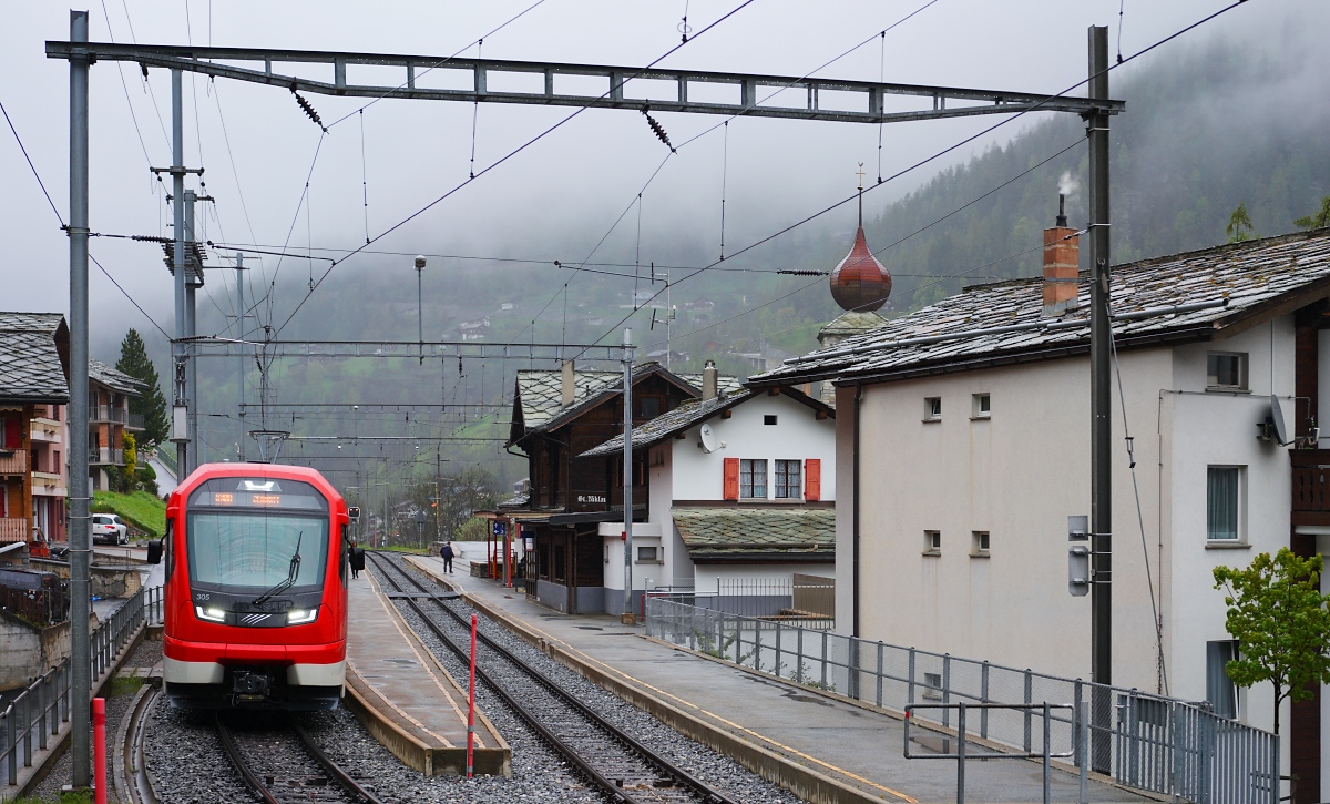 Neben lokbespannten Zügen und den Komet-Triebwagen werden auf dem Zermatter Abschnitt der Matterhorn-Gottard-Bahn auch die ab 2022 beschafften ABeh 8/12 vom Typ Orion im Personenverkehr eingesetzt. Mit ihnen sollen langfristig auch die von der Furka-Oberalp-Bahn beschafften Gepäcktriebwagen vom Typ Deh 4/4 I und II ersetzt werden. Am 07.05.2024 verlässt der ABeh 8/12 305 den Bahnhof St. Niklaus in Richtung Zermatt.