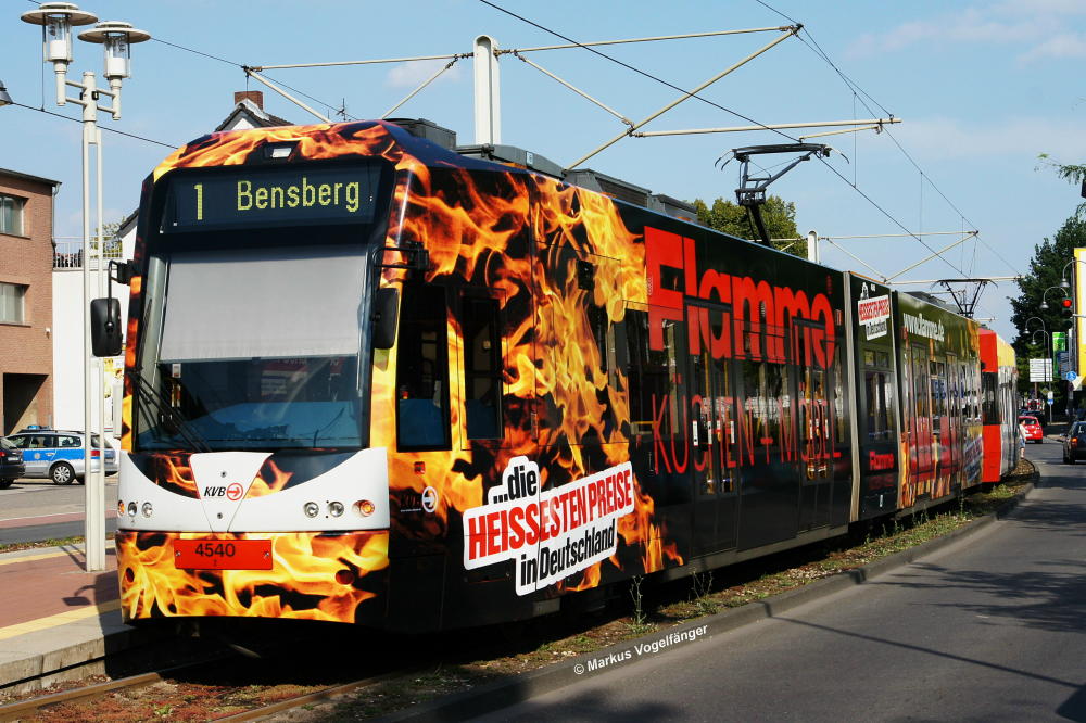 Niederflurwagen 4540 trgt als achtes Fahrzeug nach 4005, 4031, 4033, 4034, 4069, 4071 und 4111 die neue Ganzreklame  Flamme Kchen + Mbel . Hier zu sehen an der Haltestelle Weiden Schulstrae am 23.08.2013.
