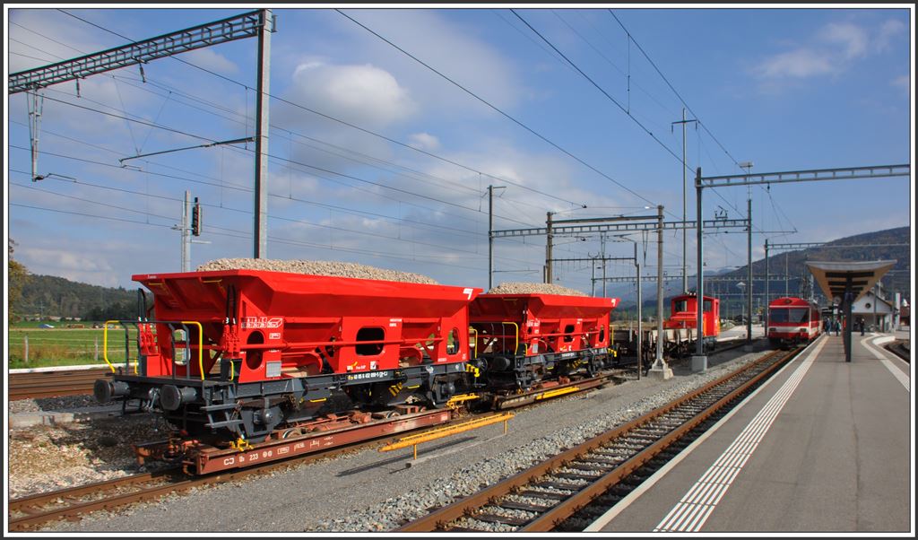 Normalspurige CJ-Schotterwagen Fcs auf schmalspurigen CJ-Rollschemel Ua in Glovelier. (09.10.2015)