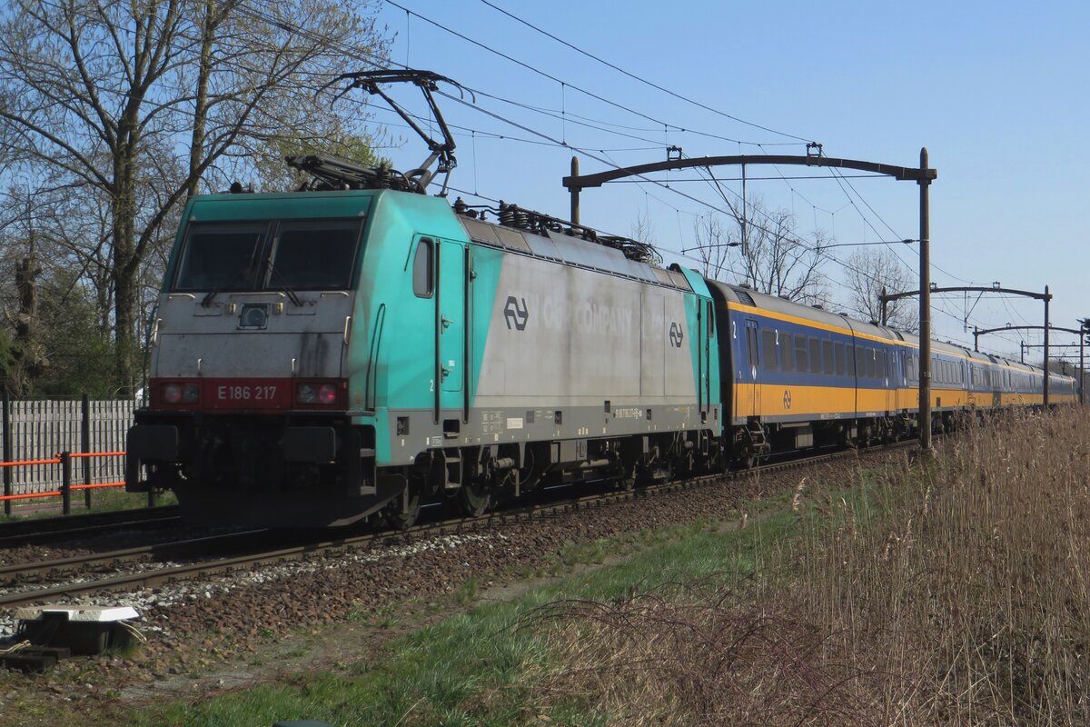 NS 186 217 schiebt ein IC-Direct durch Hulten am 15 April 2023 und wird vom hinter der Bahnubergang mit etwas zooming fotografiert.