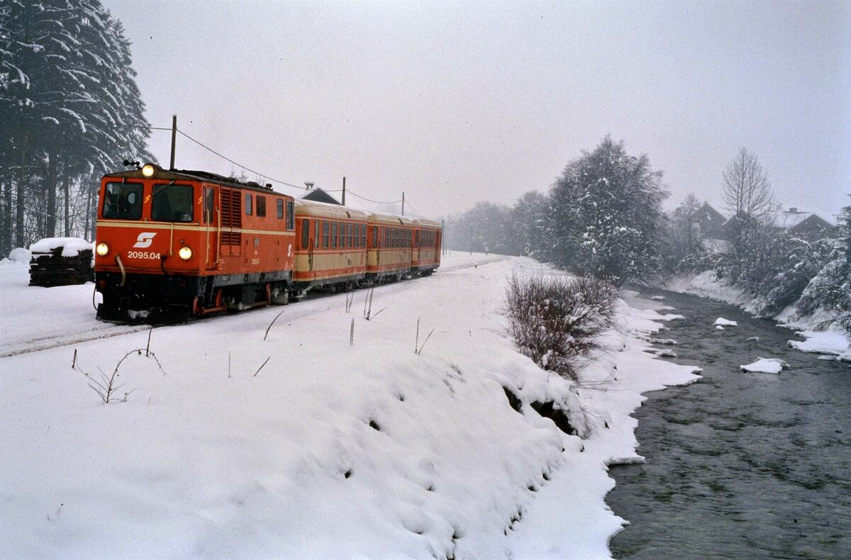 Pinzgauer Lokalbahn, ÖBB-Diesellok 2095.04 vor einem kleinen Zug im Winter 1986.
Datum: 11.02.1986