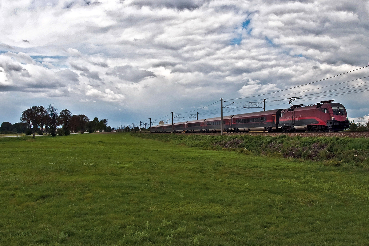 railjet 63 ist nach Budapest unterwegs. Die Aufnahme entstand am 16.08.2014 zwischen Himberg und Gramatneusiedl.