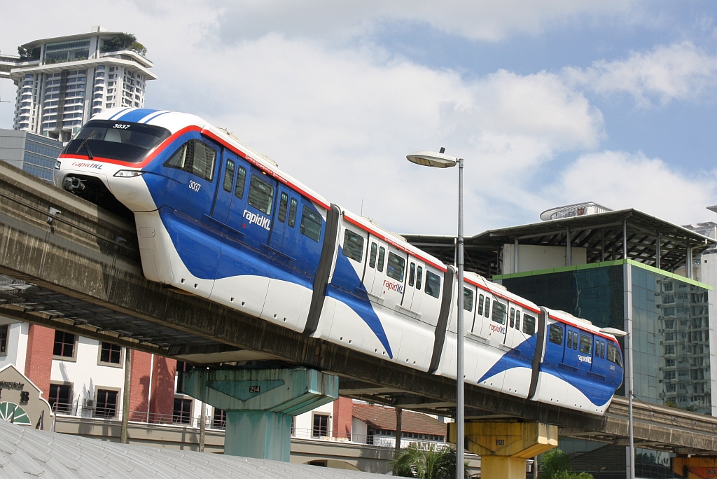 rapidKL Monorail Garnitur 30 mit den Nummern 3037 - 3040 (Hersteller: Scomi Rail, Type SUTRA) am 13.Dezember 2023 von der Stesen Maharajalela (MR3) kommend kurz vor der Stesen Tun Sambanthan (MR2).