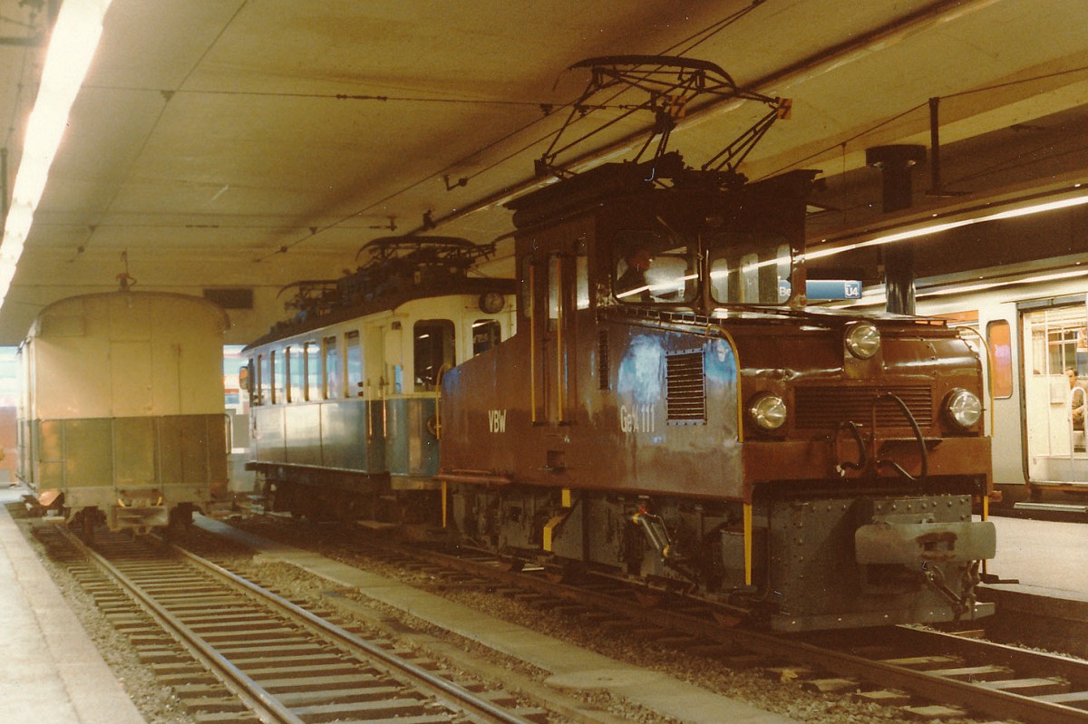 RBS/SZB/VBW: „50 JAHRE UNTERIRDISCHER RBS-BAHNHOF BERN AM 20. NOVEMBER 2015“
Am 20. November 1965 wurde der neue Tiefbahnhof Bern feierlich eröffnet. Ab dem 26. Mai 1974 starteten und endeten auch die neuen Pendelzüge Be 4/8 aus dem Worblental der Linie W (heute S7) im neuen Bahnhof Bern SZB. Dadurch wurde die Fahrdrahtspannung auf dieser Strecke von 800 auf 1250 Volt umgestellt. Mit der Verabschiedung des letzten VBW-Zuges vom 25. Mai 1974 auf dem Kornhausplatz sind die BLAUEN BÄHNLI für immer aus dem Worblental verschwunden. Einer Bilderausstellung im Mai 1984 war es zu verdanken, dass ein BLAUES BÄHNLI im Bahnhof RBS Bern verewigt werden konnte. Der Be 4/4 30 aus dem Jahre 1910 (ehemals VBW)  wurde mit der Güterlokomotive Ge 4/4 111, 1927 (ehemals Hagener Strassenbahn) überführt. Diese Lokomotive ist unter beiden Fahrdrahtspannungen einsetzbar. Die Momentaufnahme vom 25. Mai 1984 dokumentiert das seltene Trio im Bahnhof SZB Bern mit Z 2, Be 4/4 30 und der Ge 4/4 111.
Foto: Walter Ruetsch
