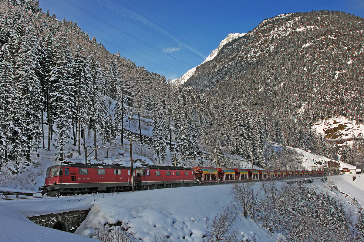 Re 10/10 bestehend aus der Re 4/4 II 11308 und der Re 6/6 11645 Colombier sind mit einem Weiacher Schotterzug auf der 3.Ebene in Wassen.Bild vom 3.2.2015