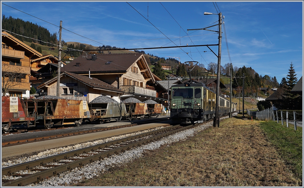 Schönried mit seinem wunderschönen Stationsgebäude und den herrlich krummen Holzmasten. Auf Gleis drei erreicht die MOB GDe 4/4  Schokoladenzuglok  mit ihrem Classic Goldenpass Zug 2217 von Saanenmöser nach Montreux den Bahnhof.
29. Okt. 2016