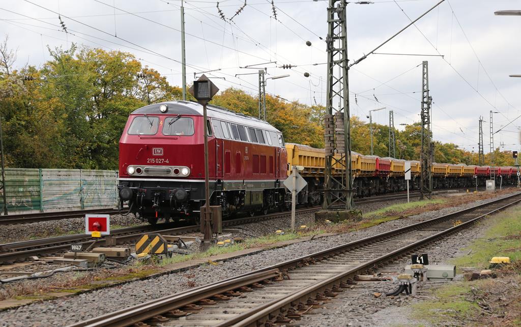 Seit dem 14.10.2019 ist die Rollbahn zwischen Osnabrück und Münster für einige Wochen voll gesperrt. U. a. sind auch im Bahnhof Lengerich, wie hier am 15.10.2019 zu sehen, Gleis Bauarbeiten im Gange. Zur Zeit läuft zwischen Lengerich und Münster noch der Regionalverkehr, der in Richtung Osnabrück als Schienen Ersatz Verkehr angebunden ist. 
Am 15.10.2019 bekam ich vom Gelände der Eisenbahnfreunde Lengerich aus die im Bau Zug Dienst eingesetzte EfW Lok 215027-4 vor die Linse. Die Lok trägt seitlich aber noch die ex DB Nummer mit 225027-4, was sie als umgebaute 215 kennzeichnet. Ansonsten ist die Lok, wie man sehen kann, nahezu im Ursprungszustand hervorragend aufgearbeitet und hergerichtet worden.