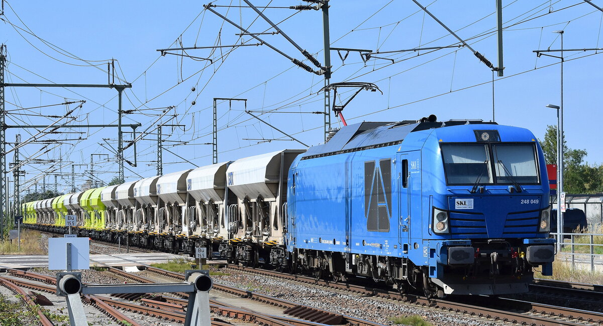 SKL Schienen Komplex Logistik Magdeburg GmbH & Co. KG, Magdeburg [D] mit der Vectron Dual Lok  248 049   [NVR-Nummer: 90 80 2248 049-9 D-NRAIL] und einem Schotterzug (leer) am 02.09.24 Höhe Bahnhof Rodleben.