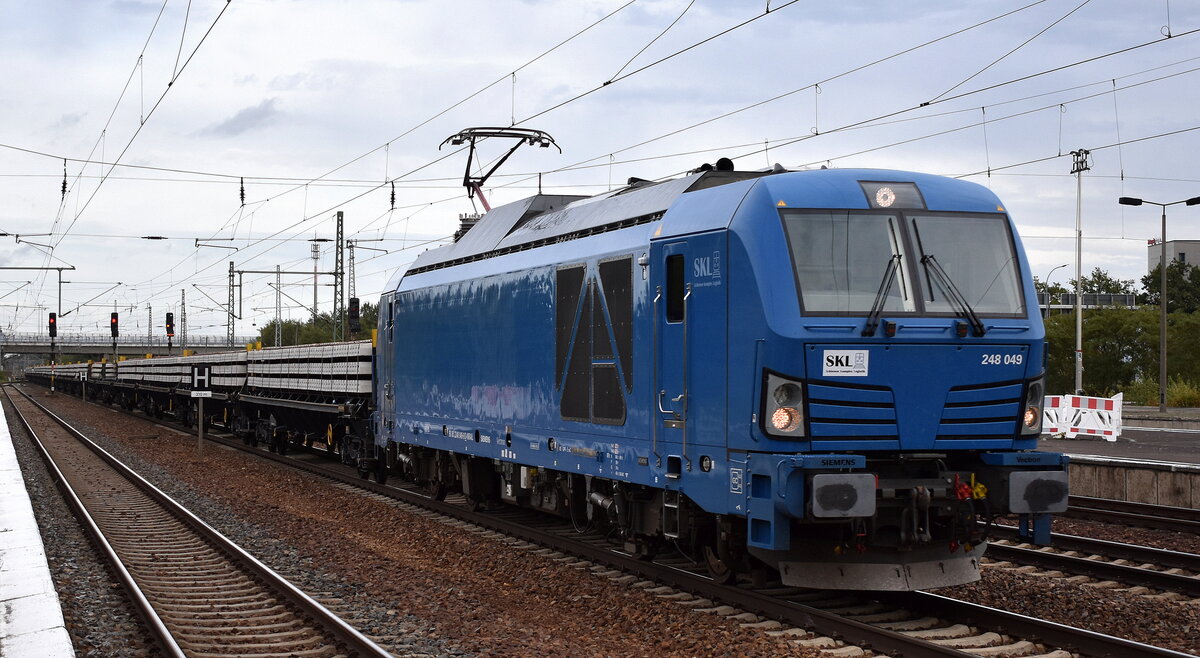 SKL Schienen Komplex Logistik Magdeburg GmbH & Co. KG, Magdeburg [D] mit der Vectron Dual Lok  248 049  [NVR-Nummer: 90 80 2248 049-9 D-NRAIL] mit einem Ganzzug Drehgestellwagen für Oberbaustoffe (DB Bahnbau Gruppe) mit Betonbahnschwellen am 14.10.24 Höhe Bahnhof Schönefeld b. Berlin.