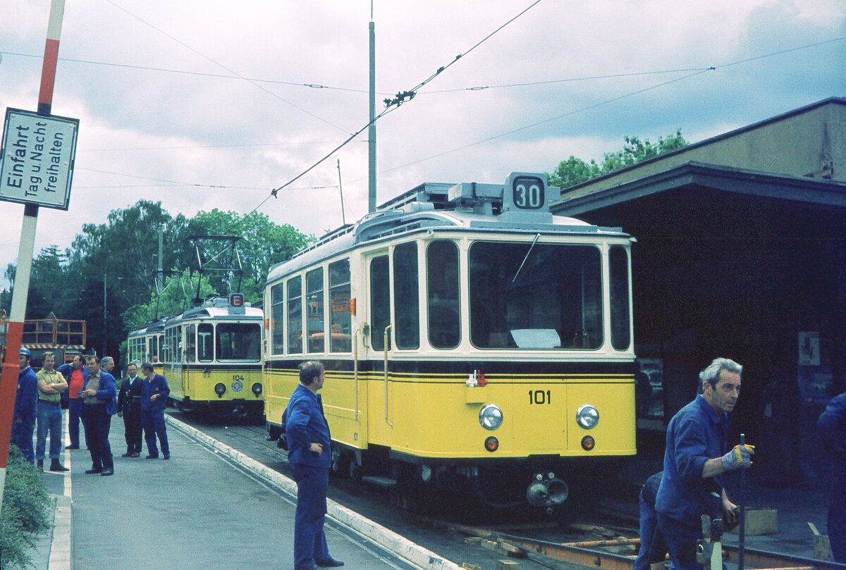 SSB Stuttgart__Zahnradbahn__Tw-Parade im Zbhf. Degerloch. Tw 104 noch im alten Look, 101 frisch glänzend aus der Hw zurück. Die sonst ständig auf dem Gleisende abgestellten vier Vorstellwagen  (heute undenkbar) wurden rechtzeitig in den Betriebshof gebracht um das Gleis frei zu haben.__30-05-1975 