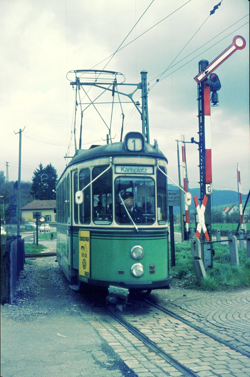 Straßenbahn Reutlingen__Die Straßenbahn in Reutlingen verkehrte das letzte Mal (auf den Linien 1 und 2) am 19. Oktober 1974. T2 (vermutlich, gemäß Werbung, Tw 56) auf Linie 1 von Eningen kommend überquert beim Südbhf. die Schienenkreuzung mit der Echaztalbahn Reutlingen-Pfullingen-Honau-Lichtenstein-Engstingen. Seit 1961 verkehrten hier Zahnrad-Schienenbusse VT 97, die von Reutlingen bis Ulm durchfahren konnten. 1969 wurde die Zahnradstrecke ab Honau eingestellt und bis Engstingen abgebaut. Zwischen Reutlingen und Honau verkehrten Schienenbusse noch bis 1980.    Vorbildlich, in weiser Voraussicht der 50 Jahre später praktizierten Persönlichkeitsschutzbestimmungen verdeckt der Fahrer sein Gesicht... Nein, so war es nicht. Vielmehr war es bei einzelnen Fahrern Ausdruck ihrer Enttäuschung über die Einstellung (1970 der nördlichen Linien 3 und 4 nach Altenburg bzw. Hagen) und der damals bereits diskutierten Einstellung der südlichen Linien 1 und 2, und über das vorausgehende viele Hin und Her mit verschiedenen Experimenten bei den Linienführungen. __24-06-1970