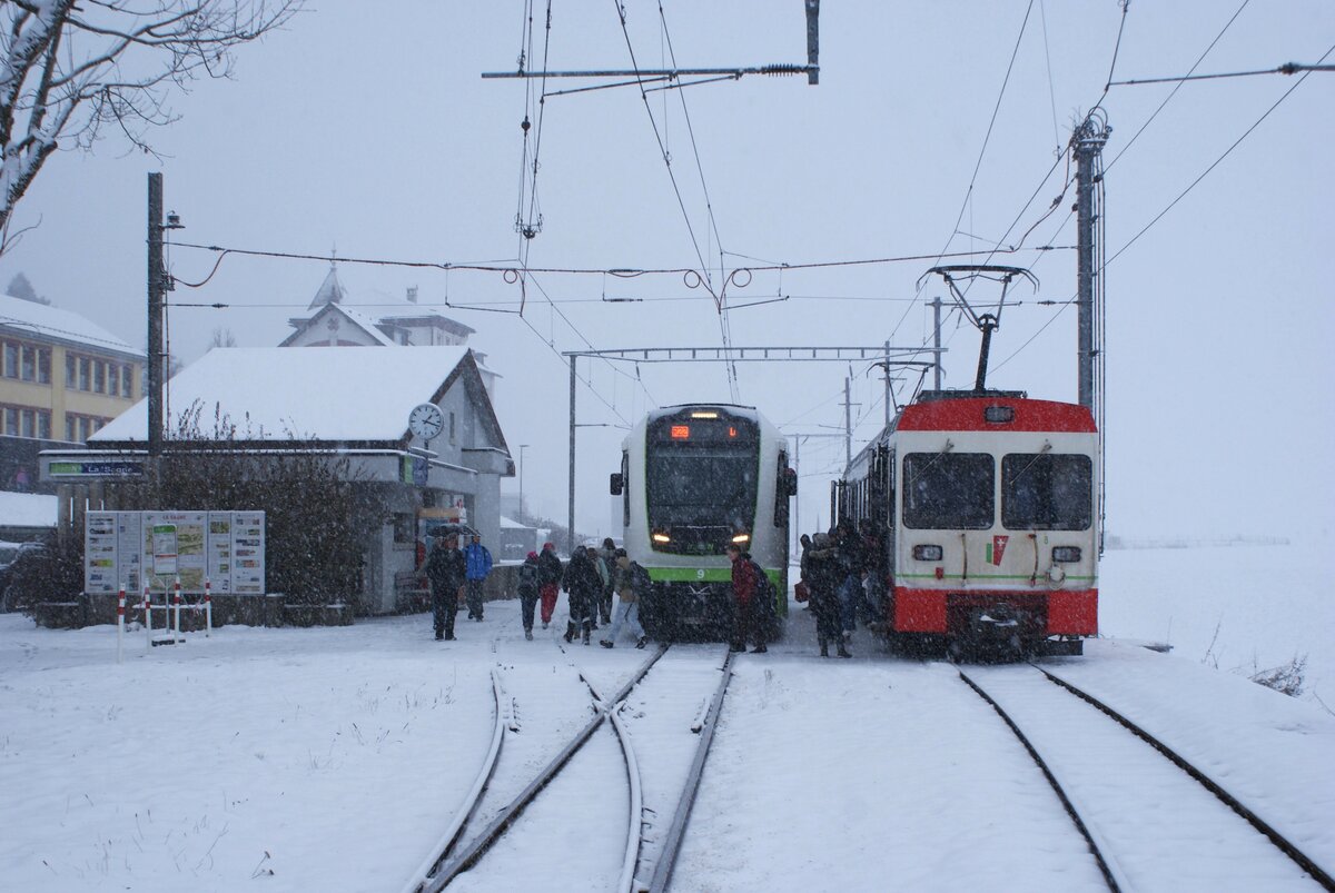 TRN PSC Transports Publics Neuchâtelois SA Bahn Les Ponts-de-Martel-La Sagne-La Chaux-de-Fonds: ABe 4/6 9 (Stadler 2024), Züge 321/320 Les Ponts-de-Martel-La Sagne-Les Ponts-d-Martel, und BDe 4/4 8 (Vevey/ABB 1996), Züge 320/321 La Chaux-de-Fonds-La Sagne-La Chaux-de-Fonds, La Sagne, 21. November 2024 (aufgenommen vom Niveauübergang aus). Die neuen ABe 4/6 fahren derzeit nicht nach La Chaux-de-Fonds, da auf einem bestimmten Fahrleitungsabschnitt Probleme auftraten mit der Stromabnahme. Transitreisende haben seit dem 12. November und bis Ende November 2024 um 07.04, 07.42 und 13.18 Uhr, Montag bis Freitag, in La Sagne umzusteigen.