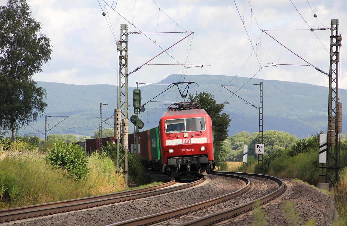 Was schleicht sich denn da um's Eck? Eine 120 mit Containerzug, genauer 120 159-9. Aufgenommen bei Wehretal-Reichensachsen am 30.07.2013.