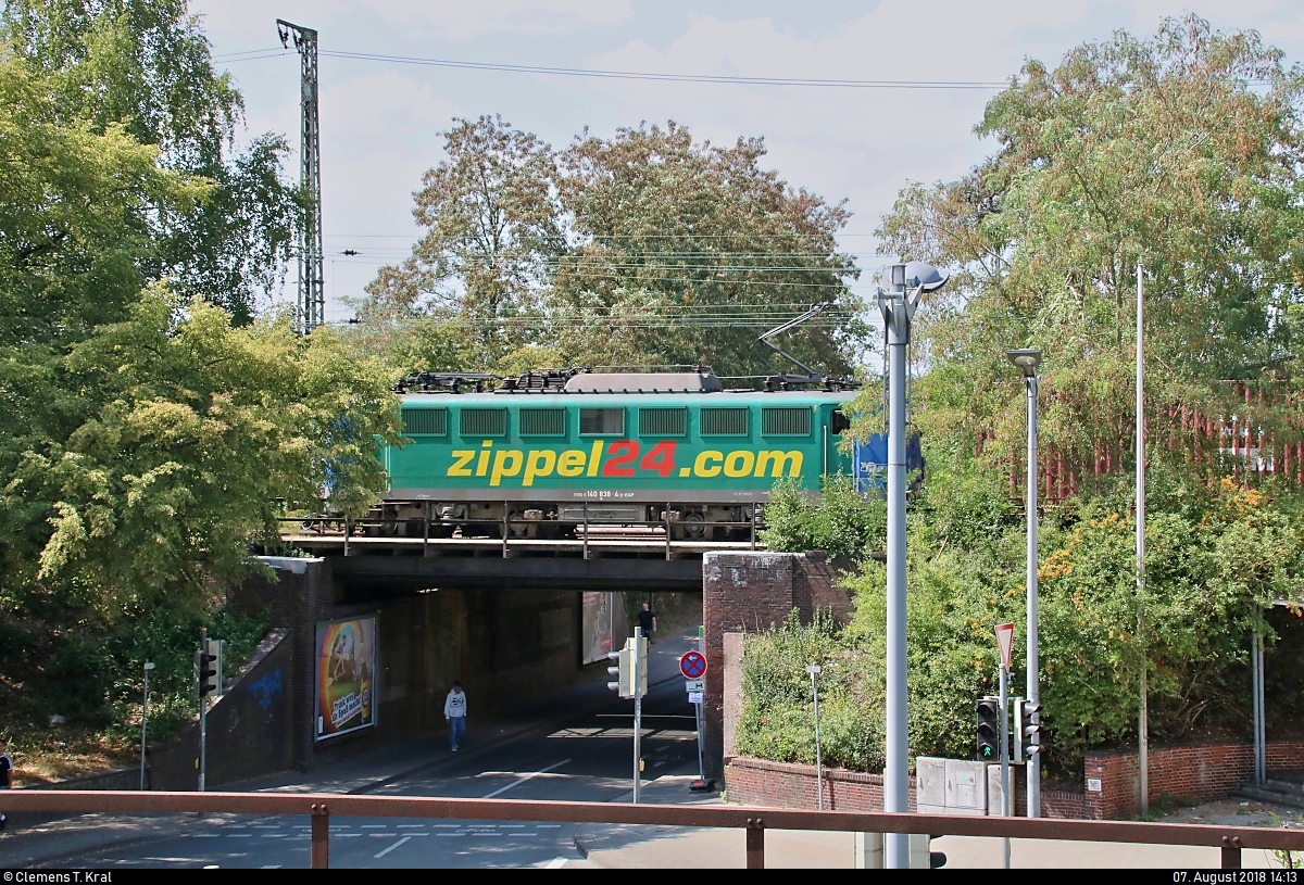 Werbung in Tarnfarbe:
Verdeckter Blick auf 140 838-4 der Eisenbahngesellschaft Potsdam mbH (EGP) mit Werbung für die Konrad Zippel Spediteur GmbH & Co. KG und Containern auf Flachwagen, die den Bahnhof Uelzen auf Gleis 301 Richtung Stendal durchfährt.
[7.8.2018 | 14:13 Uhr]