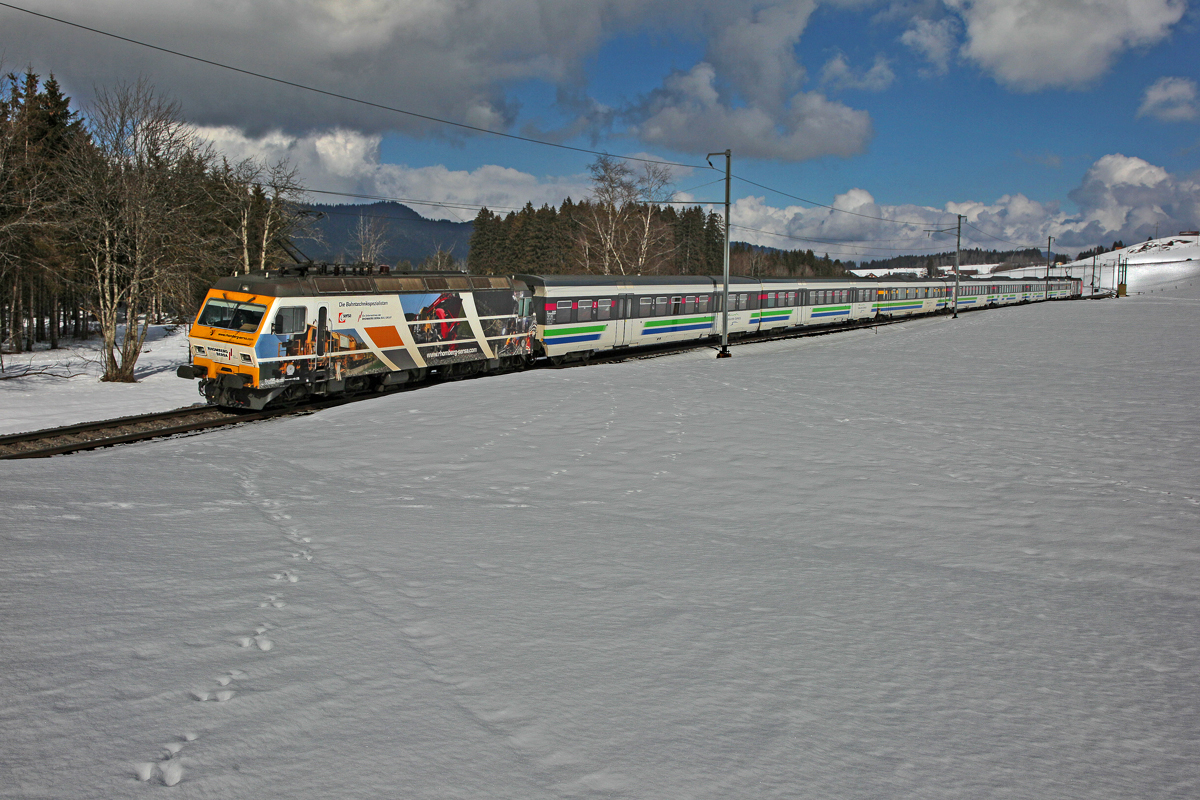 Zuglok Re 456 093 Rhomberg Sersa zusammen mit der Schublok Re 456 095 brausen mit dem Voralpenexpress bei Altmatt vorbei,links unten im Bild ist die typische Fährte eines Feldhasen der vergangene Nacht diese Stelle passiert hat zu erkennen.Bild vom 25.2.2015