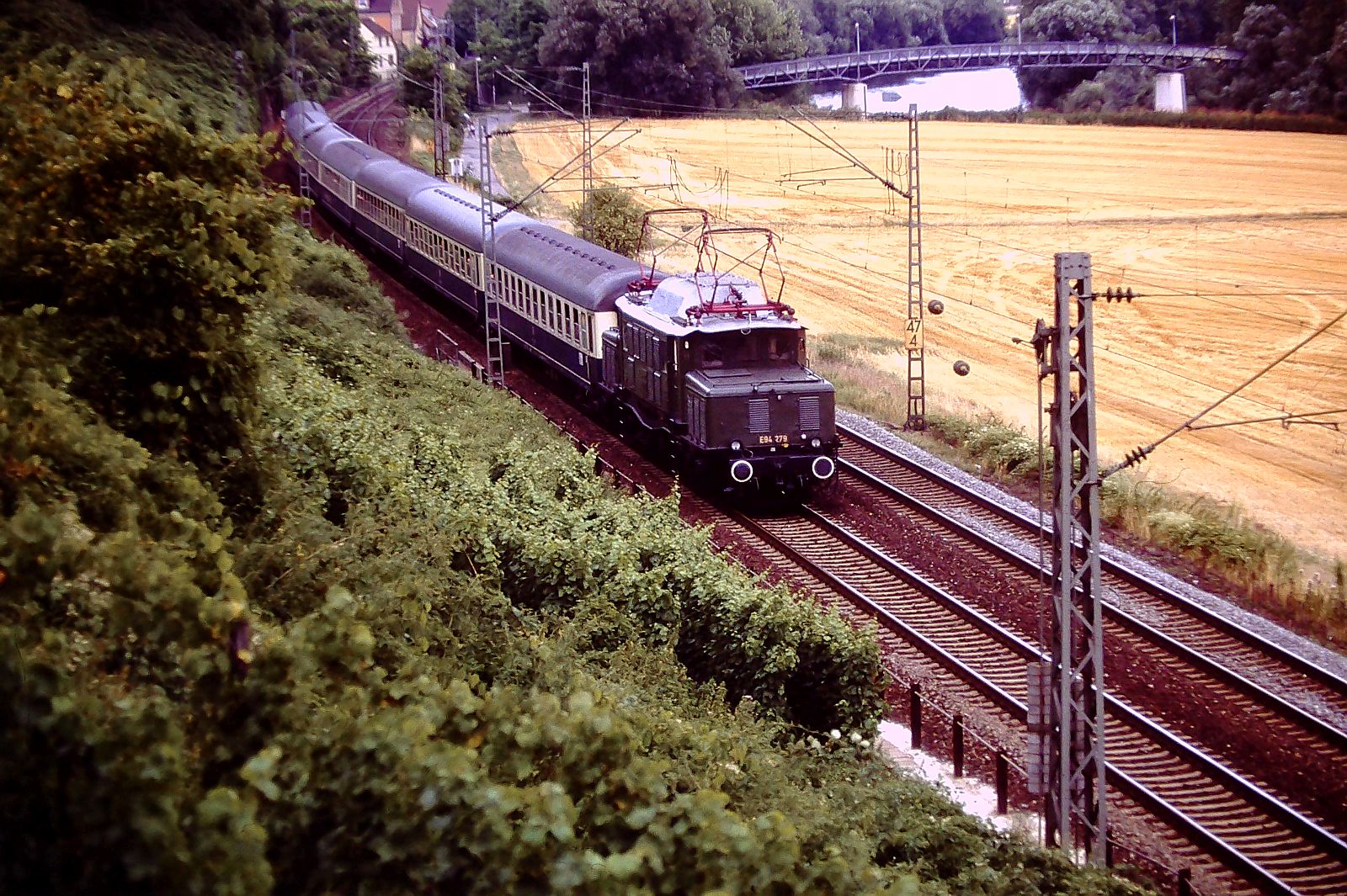 08.Aug 1991 zwischen HN-Klingenberg und Hp.-Nordheim/Württ. E94 279 mit  Dz 20307  von Heidelberg-Stuttgart. Fußgängerbrücke nach HN-Horkheim Alter Neckar-Arm