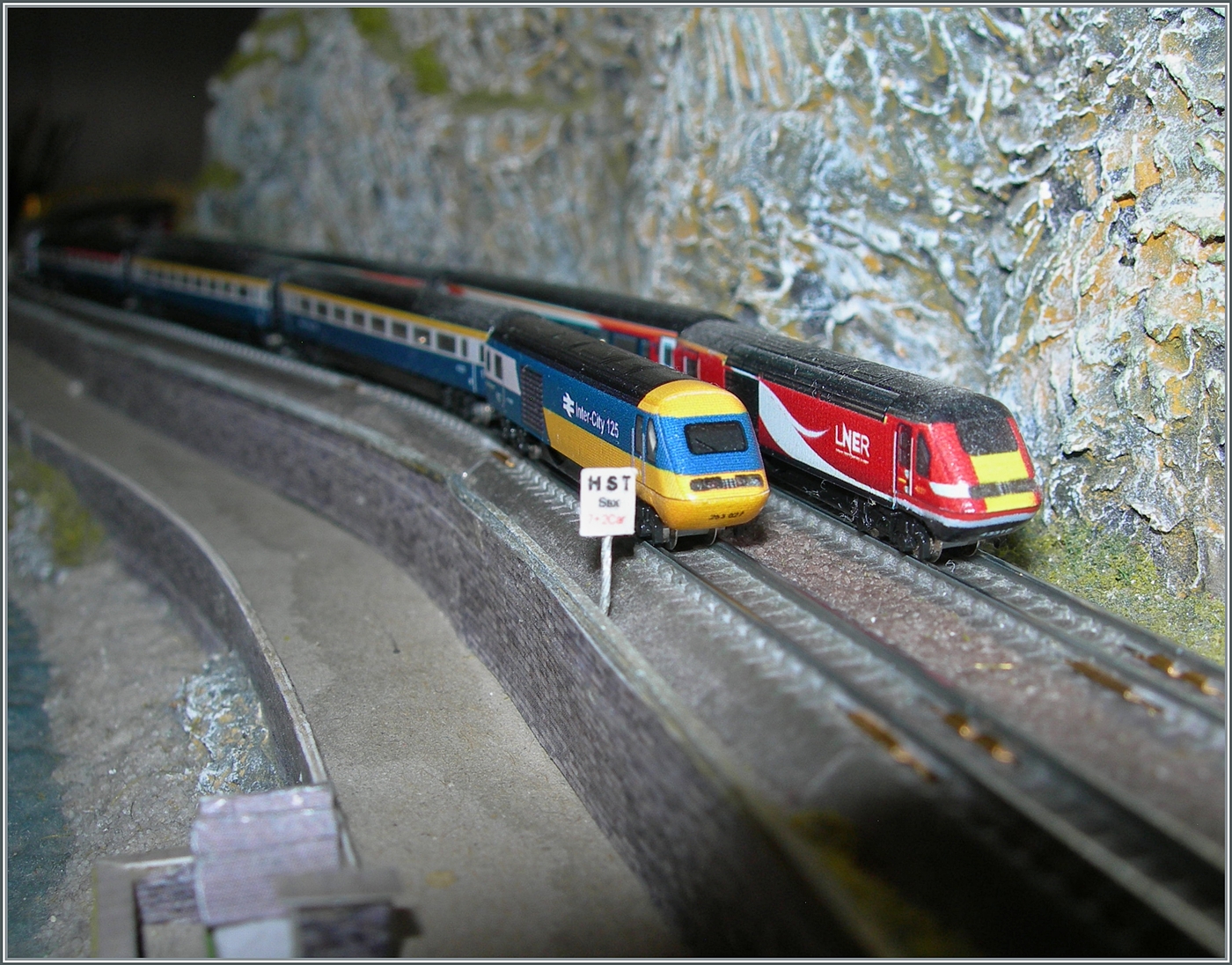 2. Dezember - Tag der Modelleisenbahn; und da gehört natürlich die kleine T-Gauge auch dazu. Immerhin schon seit elf Jahren zaubert die T-Gauge britische Ambiente in die Stube; und dieses Bild zeigt eine weitre britische Besonderheit: Ist der Bahnstieg zu kurz weisen besondere Tafeln den Lokführer auf den genauen Halteort hin. So kommen dann genau die Wagen ausserhalb des Bahnsteiges zum Halten, die dafür in den Fahrplanpublikationen vorgesehen sind.  

7. November 2024