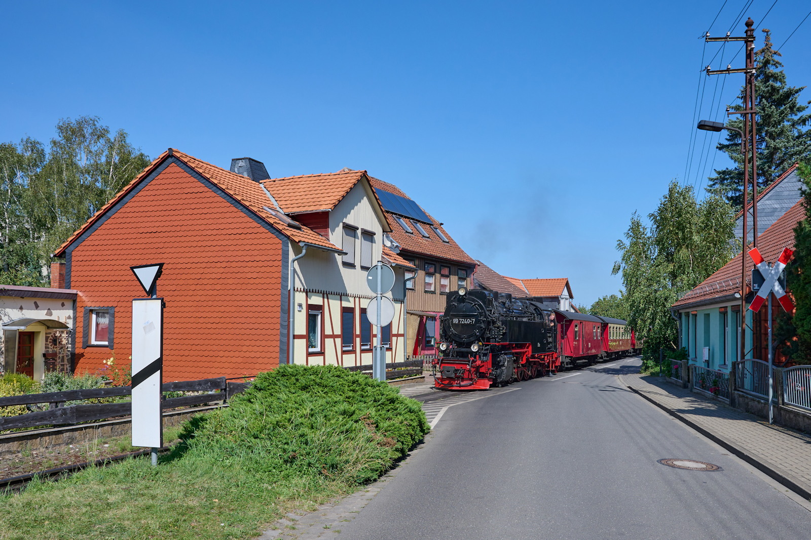 99 7240 zog am 24.08.2024 Zug 8945 von Wernigerode zum Brocken. Mit rund 10 Minuten Verspätung ging es durch die Wernigeröder Kirchstraße.