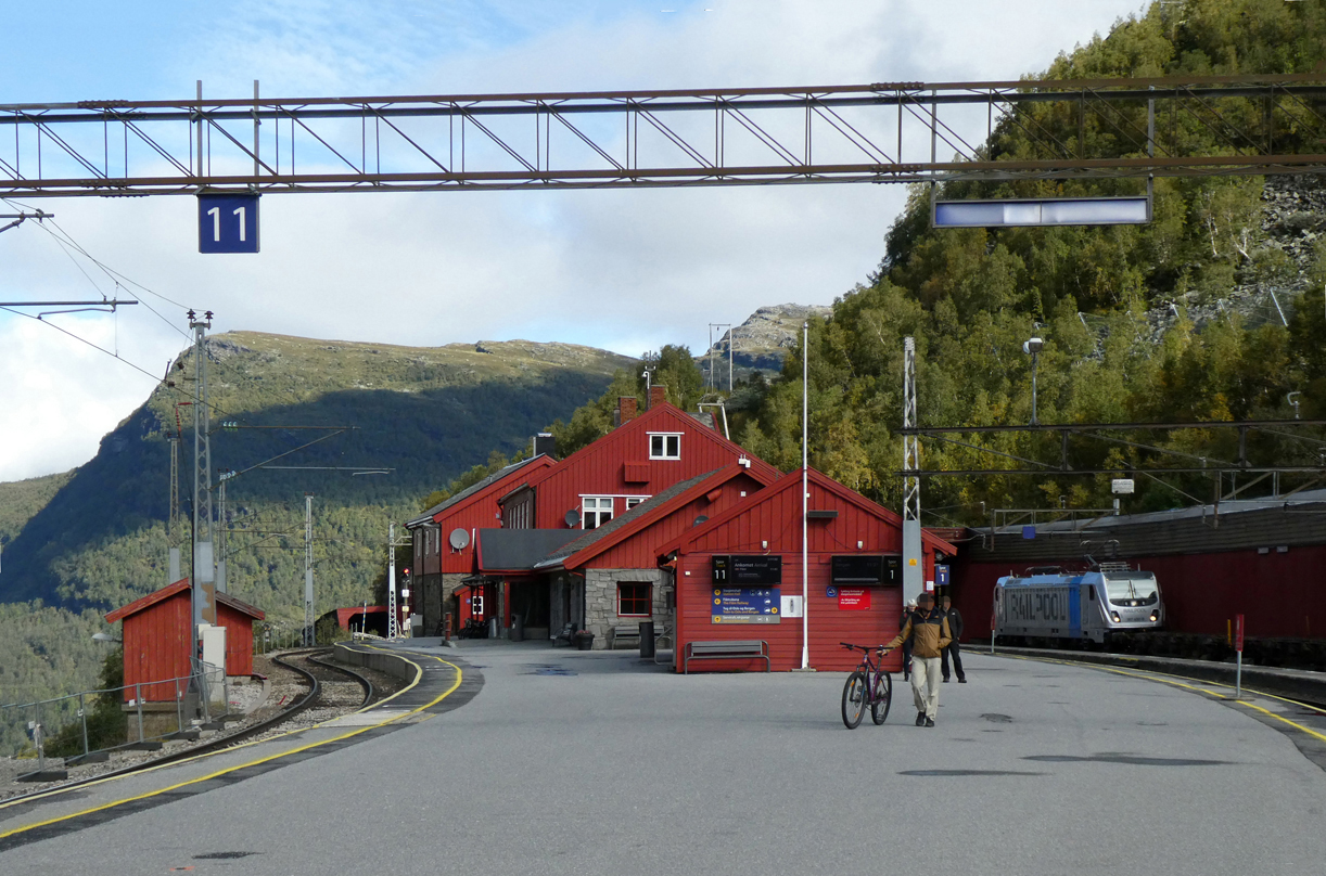 Bahnhof Myrdal: Die Reisezüge sind abgefahren, die Bahnsteige fast leer, im Hintergrund wartet die Railpool-Lok 187 400 (mit der falschen Beleuchtung?) mit ihrem Güterzug auf die Weiterfahrt. Myrdal, 31.8.2024