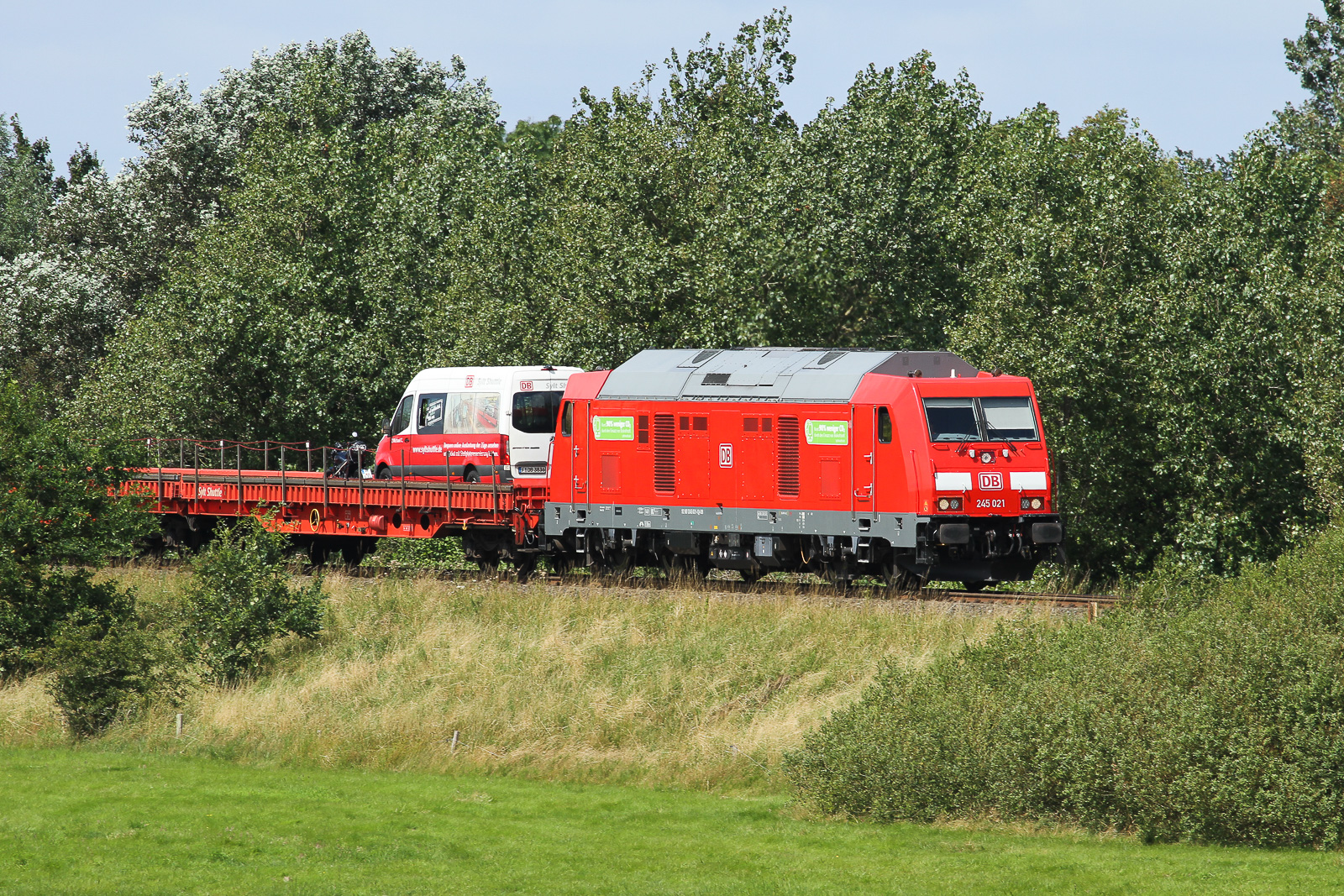 DB 245 021 fährt mit einem SyltShuttle-Autozug von Westerland nach Niebüll. Hinter der Lok steht oftmals ein kleiner Transporter der Firma als Werbung oder so. Mit 300mm Objektiv am 28.7.24 gelichtet.