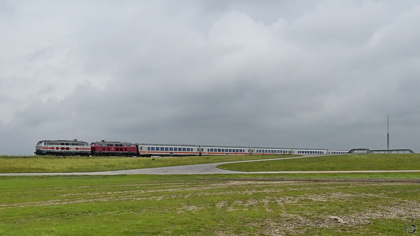 Die Diesellokomotiven 218 373-9 und 218 341-6 ziehen einen Intercity in Richtung Insel Sylt. (Friedrich-Wilhelm-Lübke-Koog, Juni 2024)